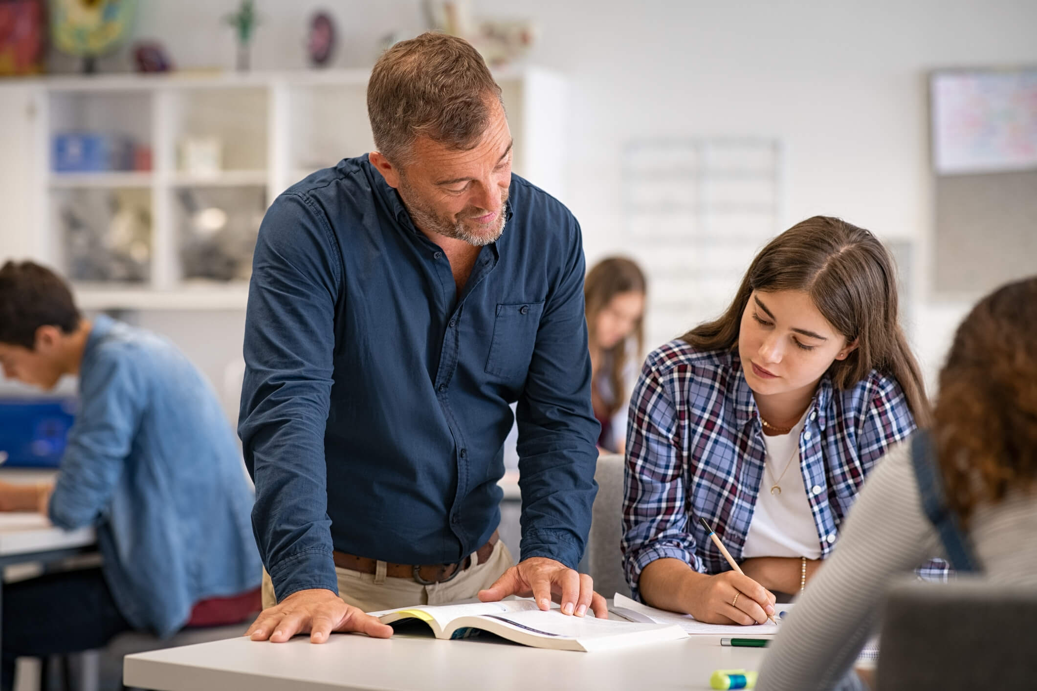 Teacher with students in classroom reviewing materials