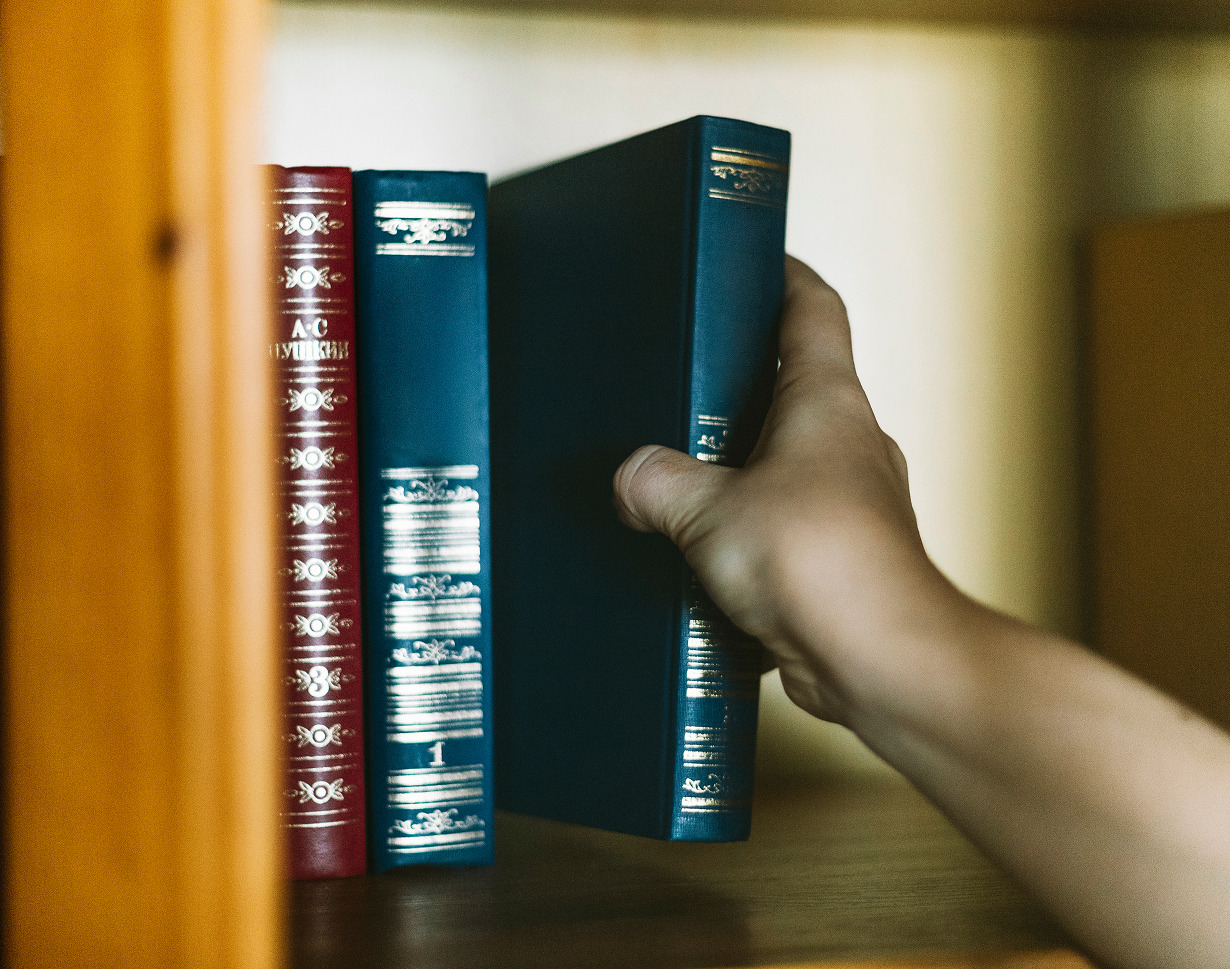 crop-hand-picking-book-from-shelf 1