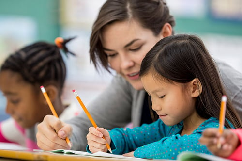 teacher-interacting-with-student-with-workbook